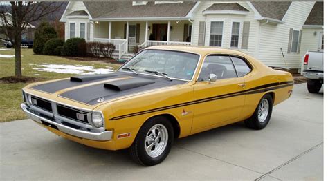 A Yellow And Black Muscle Car Parked In Front Of A House