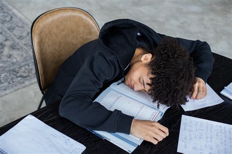 Tired Black Man Lying On Opened Book And Homework Papers · Free Stock Photo