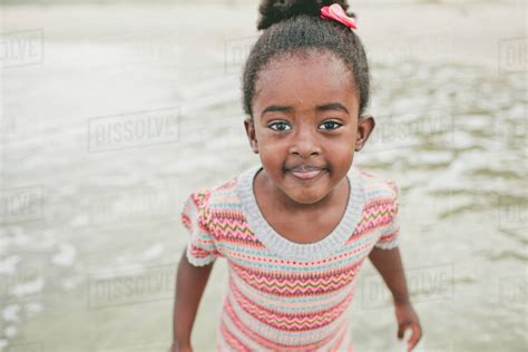 Portrait Of Smiling Girl Standing At Beach Stock Photo Dissolve