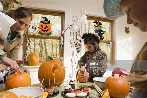 Woman And Kids Carving Pumpkins High Res Stock Photo Getty Images