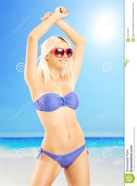 Attractive Blond Female In Bikini Wearing Sunglasses On