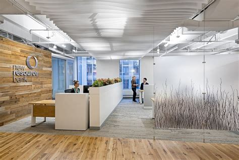 An Office With Wood Floors And White Walls Two People Standing At The