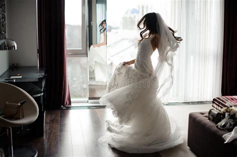 Handsome Bride In White Dress And Veil Dancing Near The Window Stock