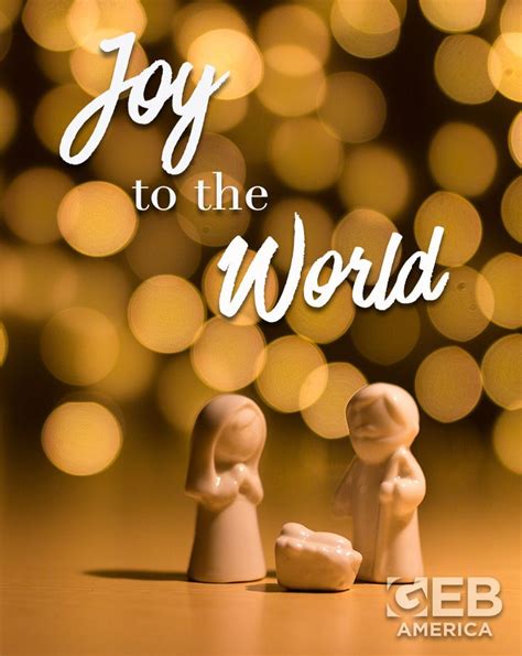 Two Small Figurines With The Words Joy To The World In Front Of Them