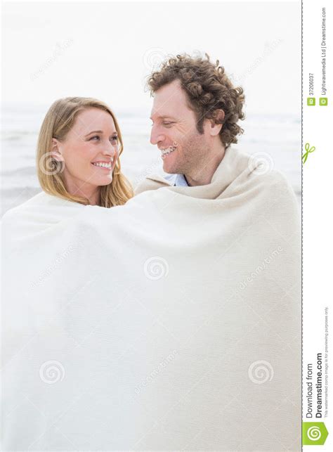 couple wrapped in blanket at beach stock image image of caucasian