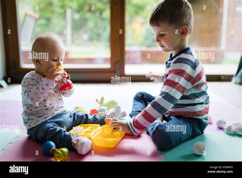 Cute Little Children Playing While Sitting On Carpet Stock Photo Alamy