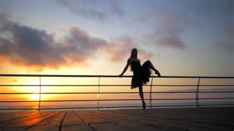 Dancing Ballerina In Ballet Tutu And Point On Embankment Above Ocean Or