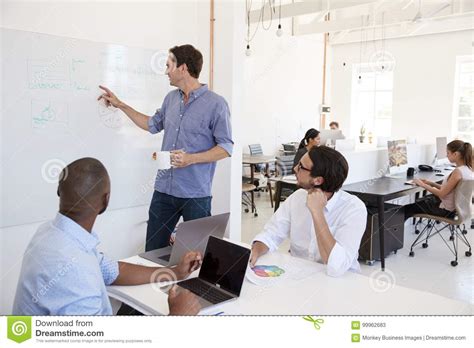 Young White Man Using A Whiteboard In An Office Meeting Stock Image