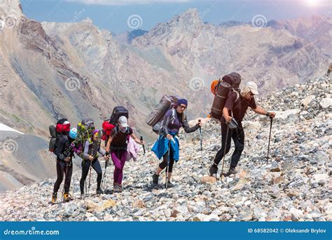 Group Of Hikers Walking On Deserted Rocky Terrain Stock Photo Image