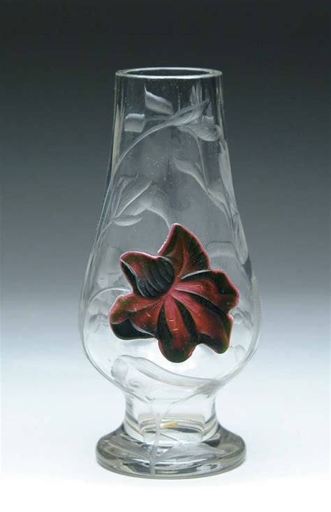 A Glass Vase With A Red Flower On It