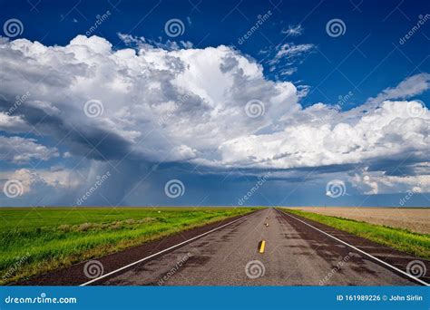 Long Straight Road Leading Towards A Storm On The Horizon Stock Photo