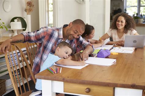 Parents Helping Children With Homework At Table Stock Photo Image Of