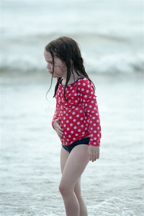 A Happy Young Boy Child Running Playing And Having Fun In The Surf And