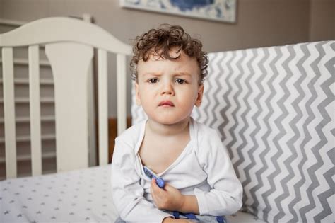 Bebê Com Febre O Menino é Uma Criança Pequena Com Um Termômetro