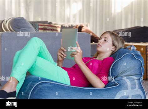 Girl Lying On A Bean Bag And Using A Digital Tablet Stock Photo Alamy