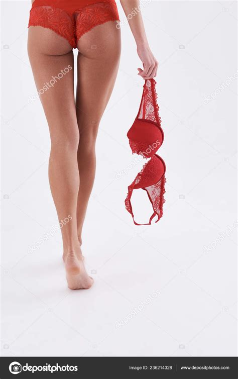 Sexy Woman In Red Panties Walking Away While Holding Lace Bra Stock
