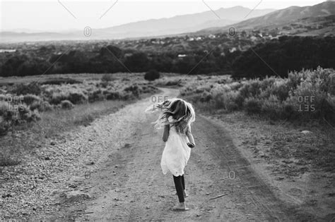 Young Girl Walking In On A Dirt Road In The Countryside Stock Photo