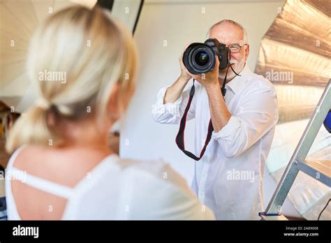 Photographer With Digital Camera Takes Portrait Photos Of Woman In The