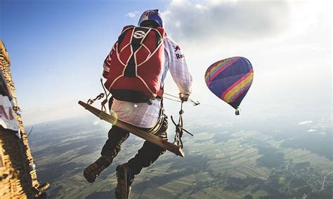watch the red bull skydive team swing between two hot air balloons in this epic stunt