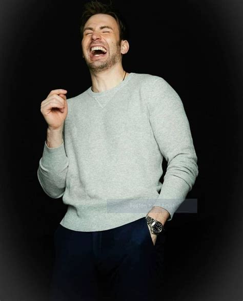 A Man Laughing While Standing In Front Of A Black Background