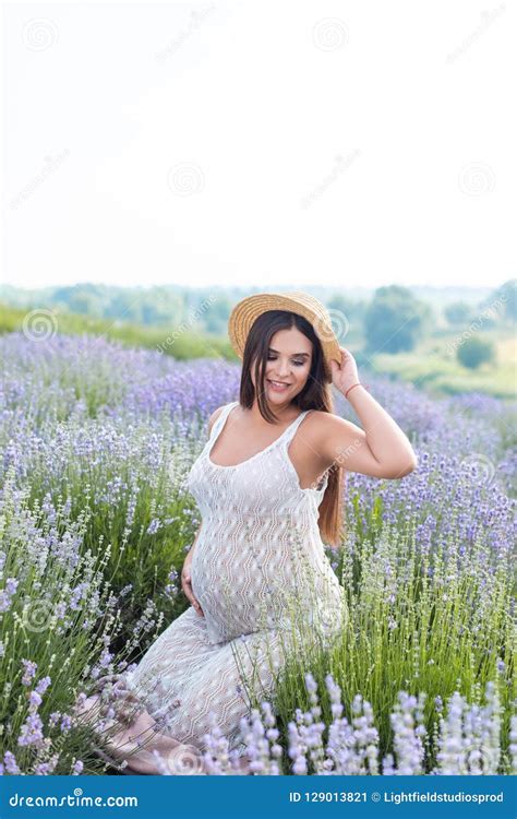 Beautiful Pregnant Woman Posing In White Dress At Violet Stock Image