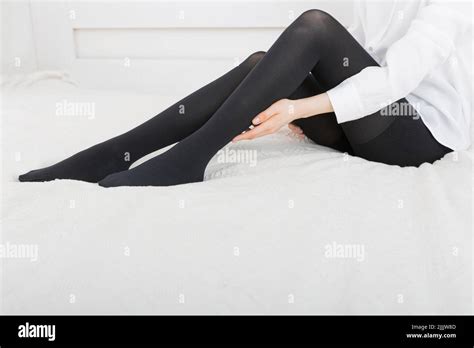 beautiful woman putting on stocking indoors closeup beautiful long female legs in stockings