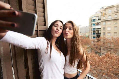 Two Girlfriends Taking Selfie On Balcony By Guille Faingold For Stocksy