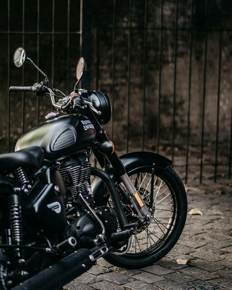 A Black Motorcycle Is Parked In Front Of A Fence And Iron Bars On The