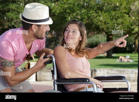 Man Pushing His Disabled Wife Through The Park Stock Photo Alamy