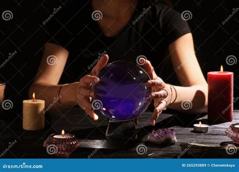 Soothsayer Using Crystal Ball To Predict Future at Table in Darkness