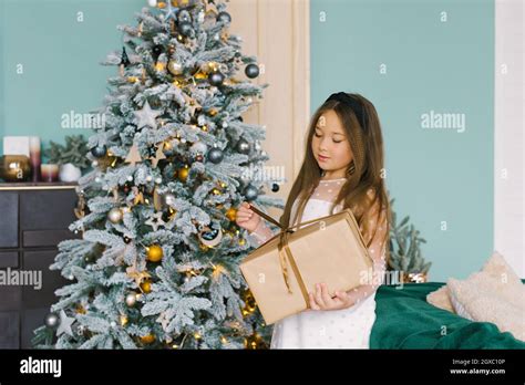 Curious Young Girl Holding Large Christmas T Stock Photo Alamy