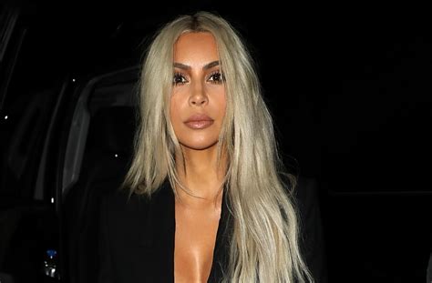 kim kardashian manages to make bermuda cut off shorts sexy by pairing with low cut bodysuit
