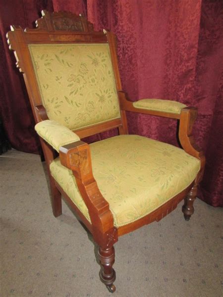 Crafted of solid wood in a warm cherry stain, this chair features a mid backrest, fixed arms, and four carved legs on hooded caster wheels. Lot Detail - ANTIQUE UPHOLSTERED CARVED WOOD ARM CHAIR