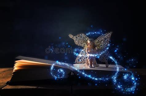 Image Of Magical Little Fairy Sitting On Old Story Book Stock Photo