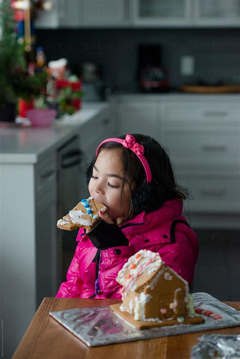 Girl Eating Gingerbread House By Stocksy Contributor Ronnie Comeau