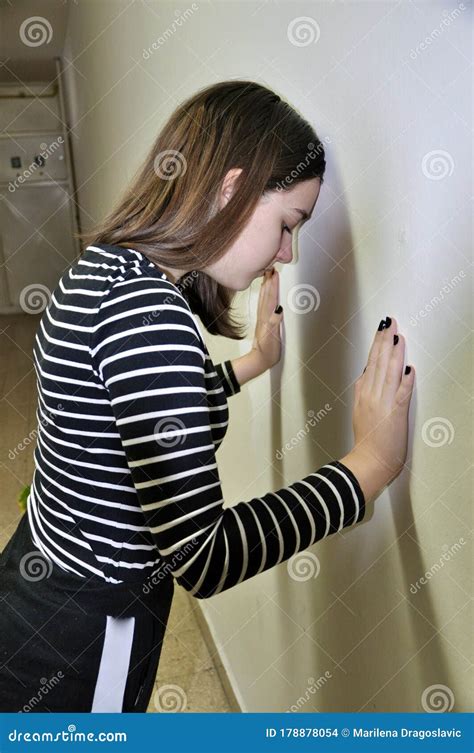 Disappointed Teenage Girl With Hands Leaning Against A White Wall Sad