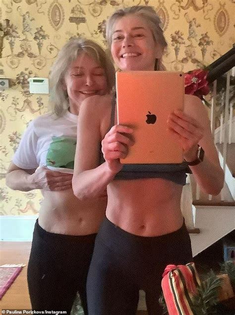 Two Women Standing Next To Each Other Holding An Apple Computer