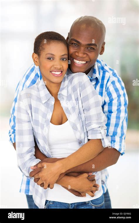 Cheerful Young African American Couple Hugging Each Other Indoors Stock