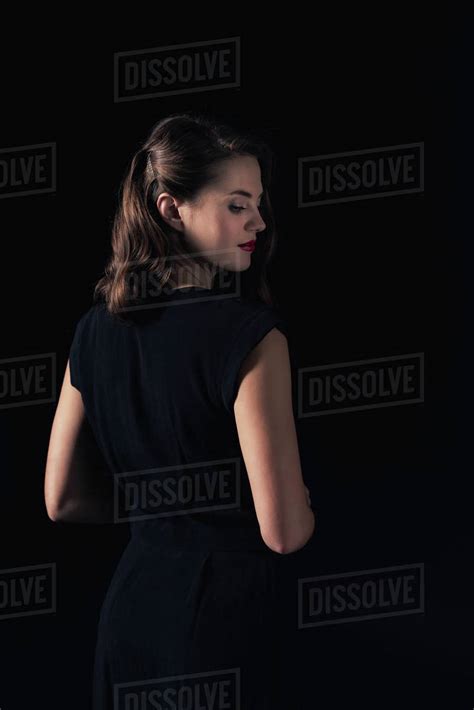 Back View Of Beautiful Woman In Dress Posing Isolated On Black Stock