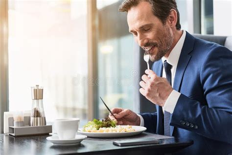 cheerful businessman eating food in restaurant stock image image of cafe male 95845291