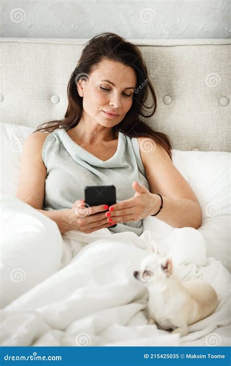 Lazy Morning Concept Beautiful Happy Woman Wakes Up In Bed And Streches Hands Attractive