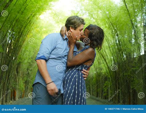 Happy Mixed Ethnicity Couple Kissing Outdoors With Attractive Black