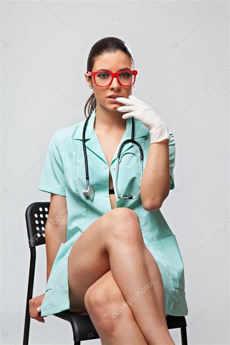 Sexy Woman Doctor With A Stethoscope And Red Glasses Sitting On Chair