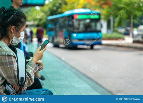 Asian Young Girl Use Smartphone Waiting For Bus At Bus Stop Editorial