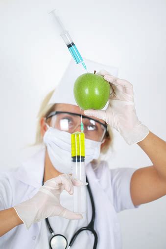 Scientist Injecting Liquid From Syringe Into Green Apple Gmo Stock