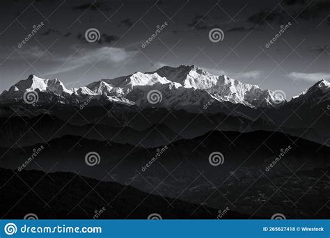Grayscale Of Beautiful Mountains With Snowy Peaks Against The Clouds