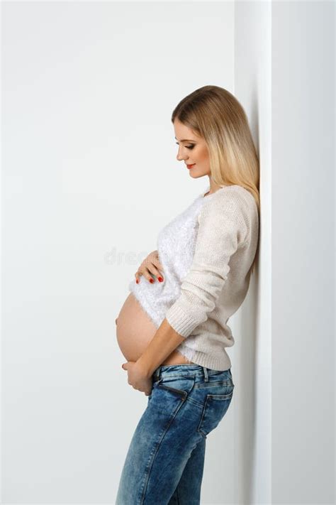 Красивая беременная женщина в джинсах Стоковое Фото изображение