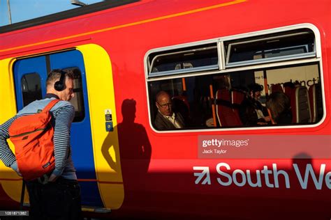 A Commuter Waits To Board A Train At Clapham Junction Station During News Photo Getty Images