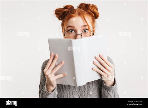 Portrait Of A Funny Young School Nerd Girl Holding Book At Her Face