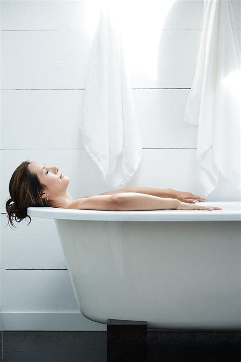 Hispanic Woman Relaxing In Bathtub In Bathroom Smiling By Stocksy Contributor Trinette Reed